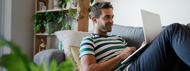 Hombre utilizando una computadora en el sillón