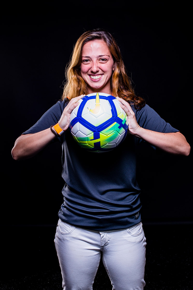 Júlia Vergueiro segurando uma bola de futebol