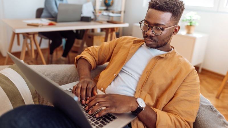 Man using laptop on couch mobile