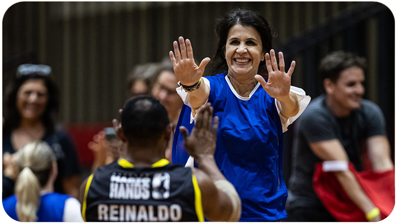 Mulher sorridente dando high-fives em um atleta em comemoração