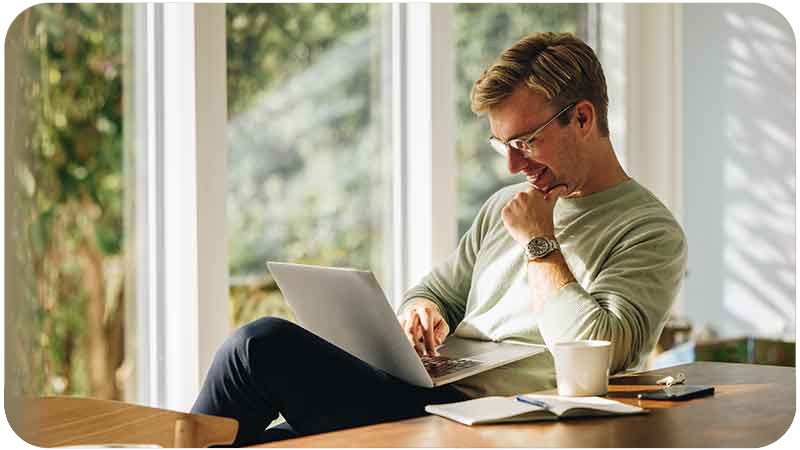 Homem sorridente trabalhando confortavelmente em casa