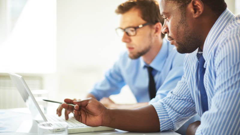 Dois homens analisando algo no computador