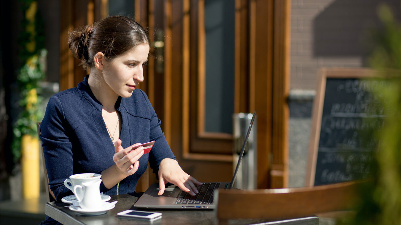 Mulher de perfil executivo faz compra online num café